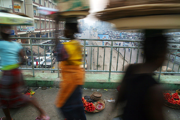 Adolphus: Vegetable sellers walk past a pedestrain bridge in Cotonou, Benin Republic