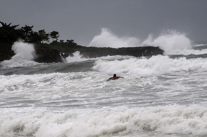 Tropical storm Isaac: Surfers swim out to sea at Manresa beach as Tropical Storm Isaac approaches