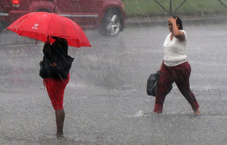 Tropical storm Isaac: Women wade through a flooded street