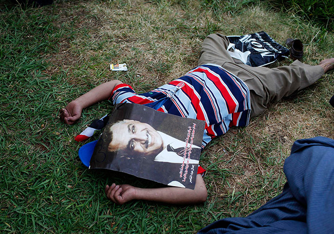 24 hours: A protester covers his face with a picture of Gamal Abdel Nasser