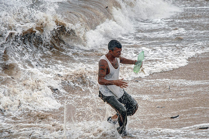 Tropical Storm Isaac: A man runs away from the waves in Gibara, Cuba