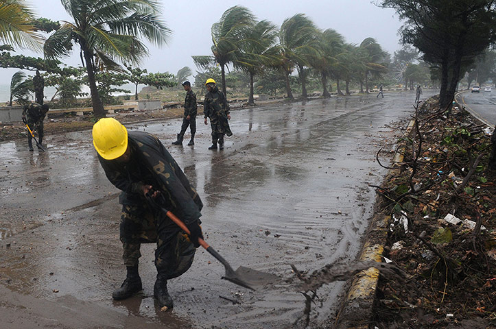 Tropical Storm Isaac: Soldiers clean a seaside road from debris left by the storm