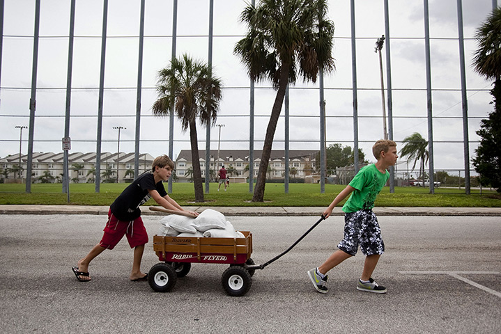 Tropical Storm Isaac: Boys wheel a cart of sandbags back to their homes St. Pete Beach, Florida