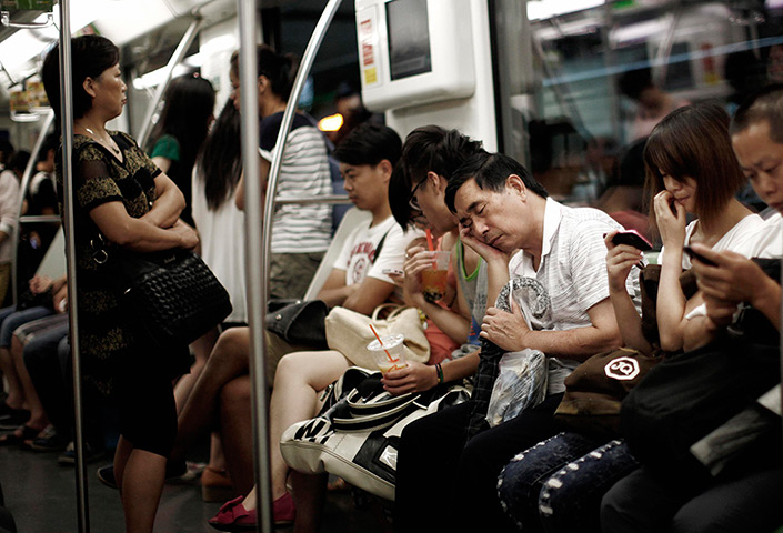 24 hours in pictures: A man sleeps while sitting inside a subway train