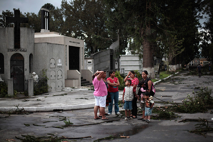 24 hours in pictures: A family reacts after a small tornado hits the the Municipal Cemetery