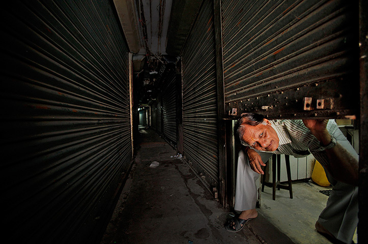 24 hours: Gauhati, Assam state, India: A shopkeeper at a closed shop during a strike