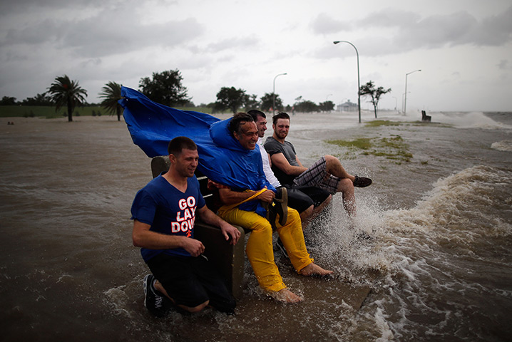 Tropical storm Isaac: A group of men sit on a bench at edge of Lake Pontchatrain in New Orleans