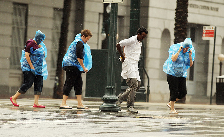 Tropical storm Isaac: People make their way across Canal Street in New Orleans