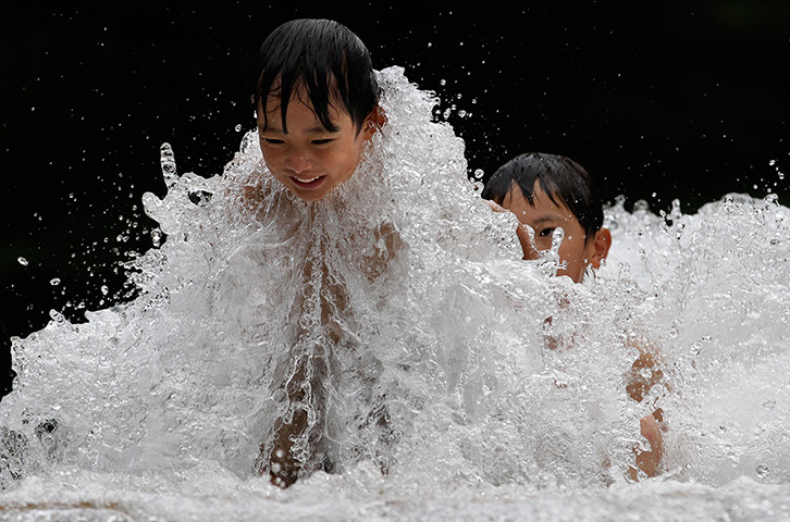 24 hours: Tokyo, Japan: Children play in a water fountain