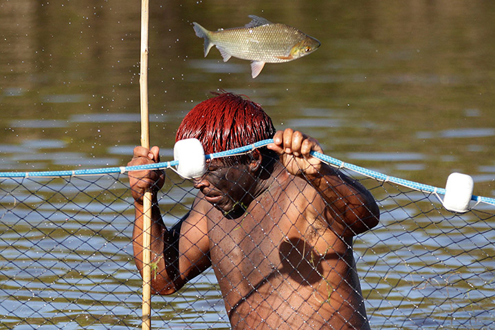 24 hours: Xingu National Park, Brazil: A Yawalapiti man fishes in the Tuatuari River