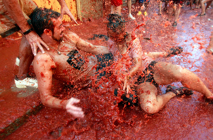 tomatina festival: A couple gets splashed in tomato pulp
