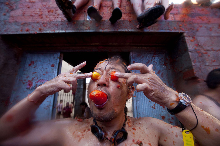 tomatina festival: A reveller presses tomatoes into his face