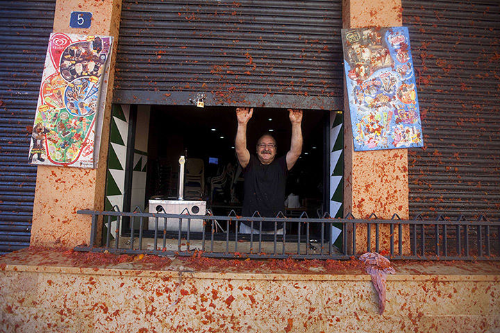 tomatina festival: A man opens the store of his buisness during the fiesta