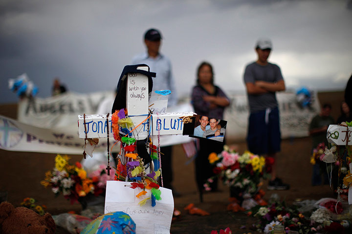 Week in Film: Mourners standing in the rain look over a memorial on 27 July