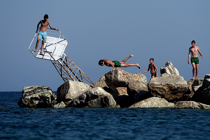 24 hours in pictures: A young boy jumps into the sea in Agii Apostoli