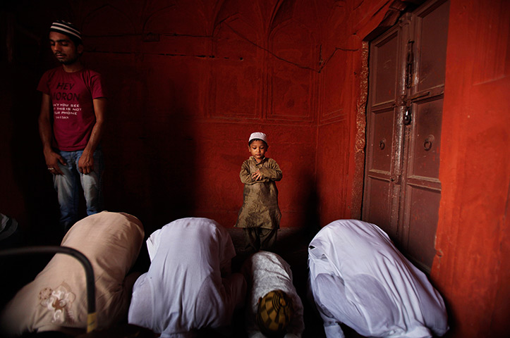 24 hours in pictures: A young Indian Muslim boy offers prayers