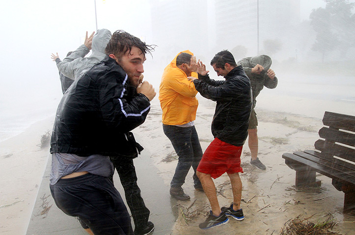 Hurricane Isaac: A group of friends stand against strong wind in Gulfport
