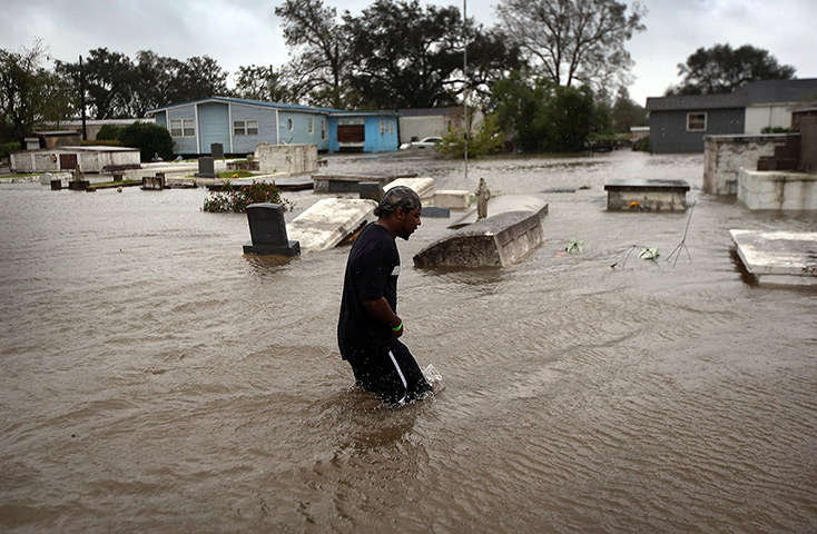 Hurricane Isaac: Errol Ragas walks past a flooded cemetery
