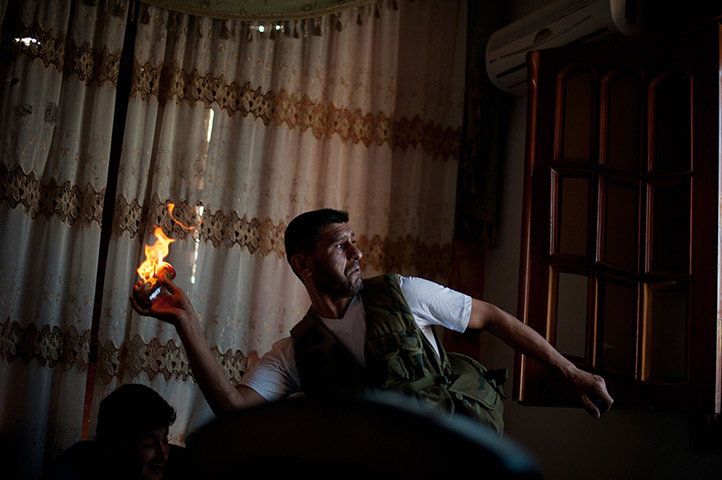 24 hours: Aleppo, Syria: An opposition fighter throws a Molotov cocktail