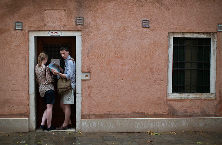 Venice architecture: A couple shelter from the rain as they study their maps of the biennale