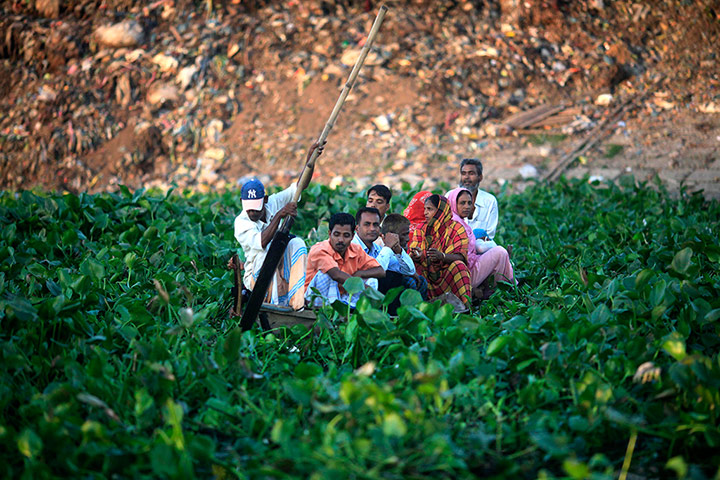 24 Hours: Dhaka, India: A boatman struggles to move his boat full of passengers