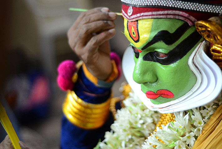 24 Hours: Chennai, India: A Kathakali dancer applies make up backstage