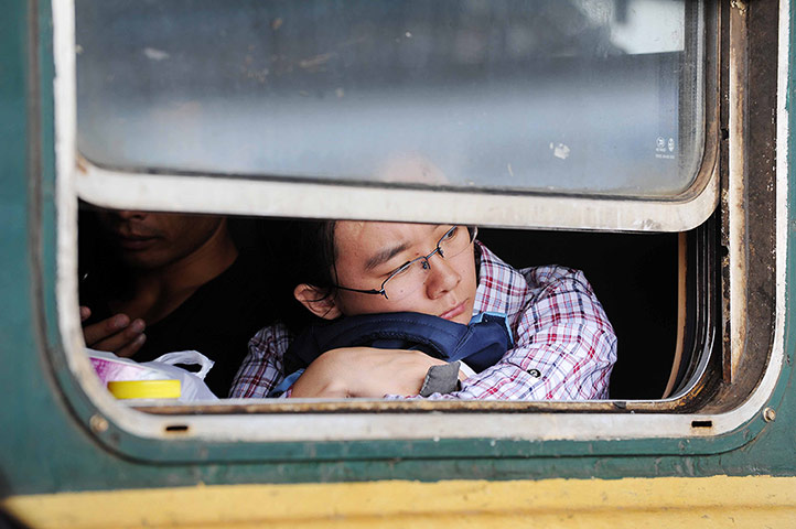 24 Hours: Yinchuan, China: A passenger looks out of the window from a train