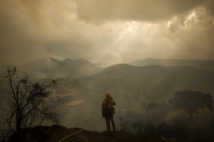 fires on costa del sol: A firefighter stands amidst smouldering countryside in Ojen 