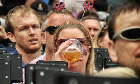 A British fan enjoys some refreshment whilst watching the morning's athletics in the Olympic stadium