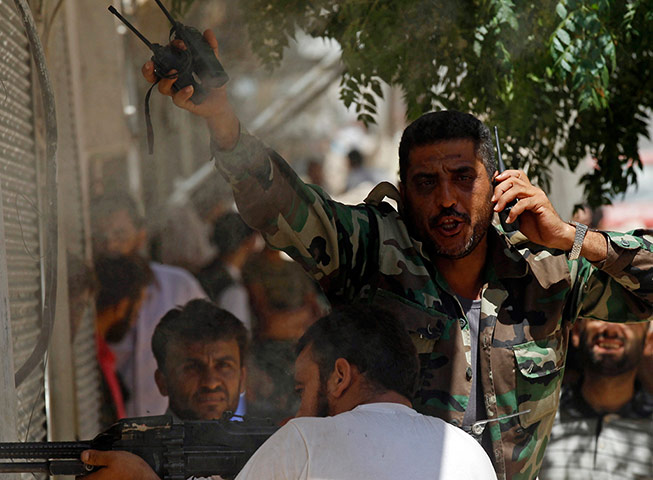 Aleppo: A Free Syrian Army fighter gestures after his friend was shot
