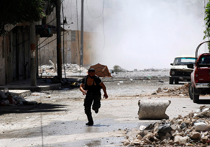 Aleppo: A man runs for cover during clashes in Syria