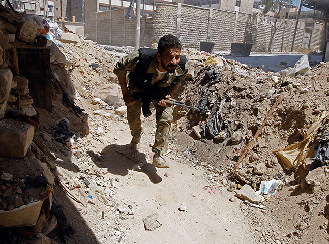 Aleppo: A Free Syrian Army fighter runs for cover