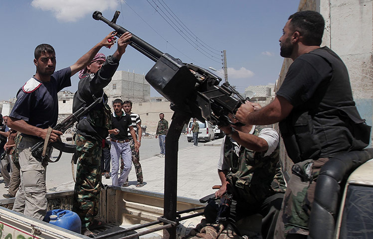 Aleppo: Syrian rebel fighters stand around an anti-aircraft machinegun