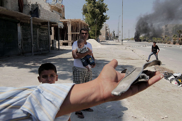 Aleppo: A Syrian youth shows shrapnel pieces
