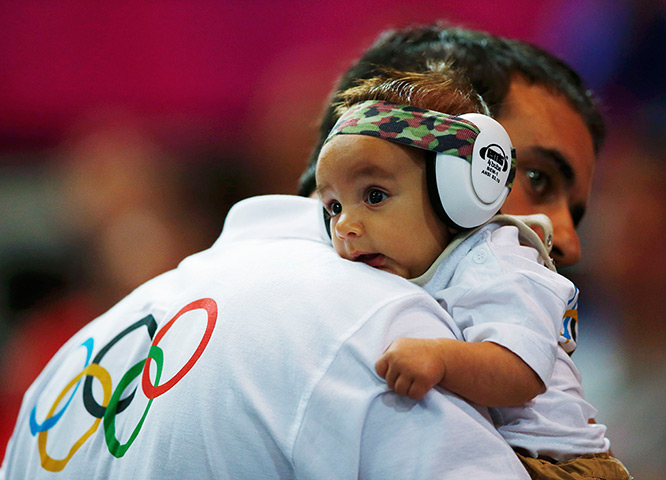 24 hours: London, England: A fan carrying his baby watches the men's handball
