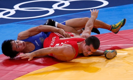 Azerbaijan's Rovshan Bayramov (in red) fights with Russia's Mingiyan Semenov in the men's 55Kg Greco-Roman wrestling qualification at the ExCel venue