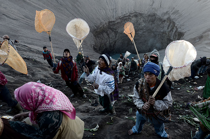 Mount Bromo: People try to catch the various items being thrown into the crater 