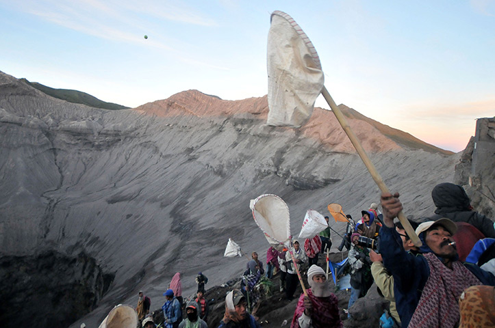 Mount Bromo: Villagers trying to catch offerings thrown by worshippers into the crater 