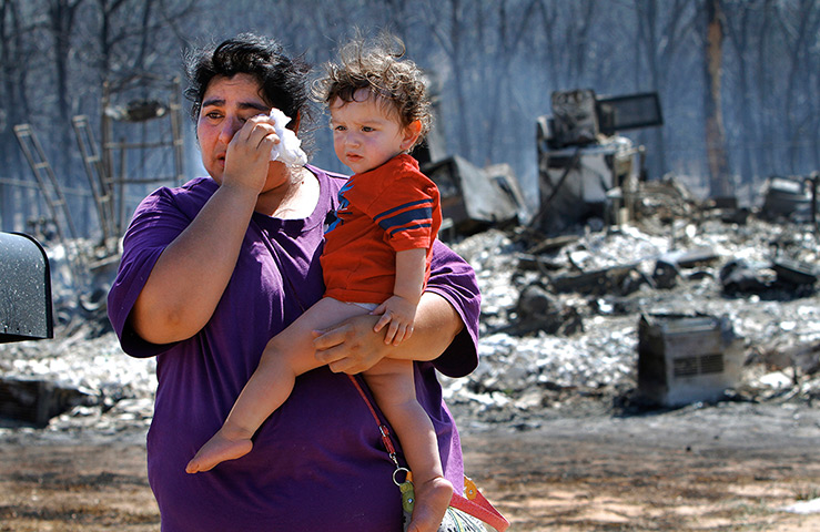 Oklahoma wildfires: A woman wiping tears  at their former home in Luther