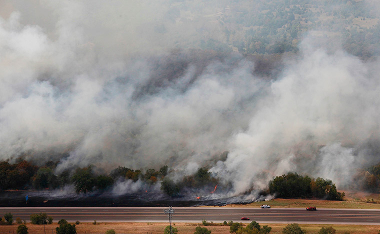Oklahoma wildfires: Firefighters fight a fire next to the Turner Turnpike near Tulsa
