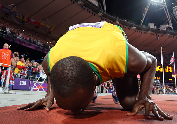 Bolt's Ticks: Usain Bolt of Jamaica celebrates winning gold by kissing the track