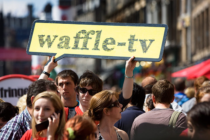 Royal Mile: A man carries a sign for waffle-tv