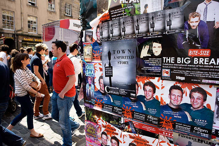 Royal Mile: A wall pasted with posters for shows at the Fringe