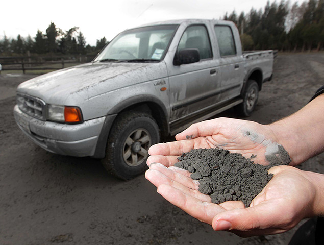 Mount Tongariro erupts: A man holds a handful of volcanic ash that fell on a property in Rangipo