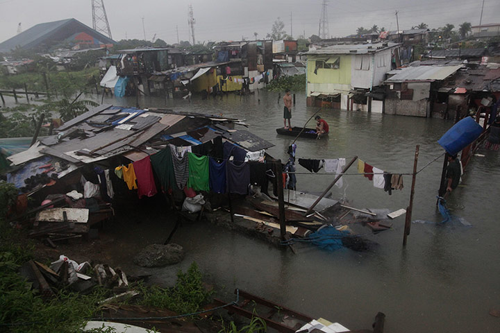 Floods in Manila: Residents ride an improvised float along a flooded area in Rizal