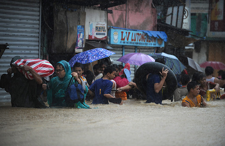 Floods in Manila: Residents wade through a flooded street