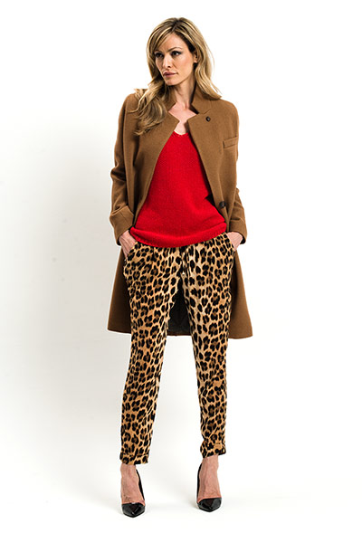 All Ages: Leopard: Model wears leopard print trousers with a red jumper and camel coat