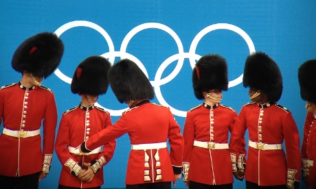 Soldiers wearing busbys pose in front of the Olympic rings at the close of the weightlifting at ExCel tonight.  