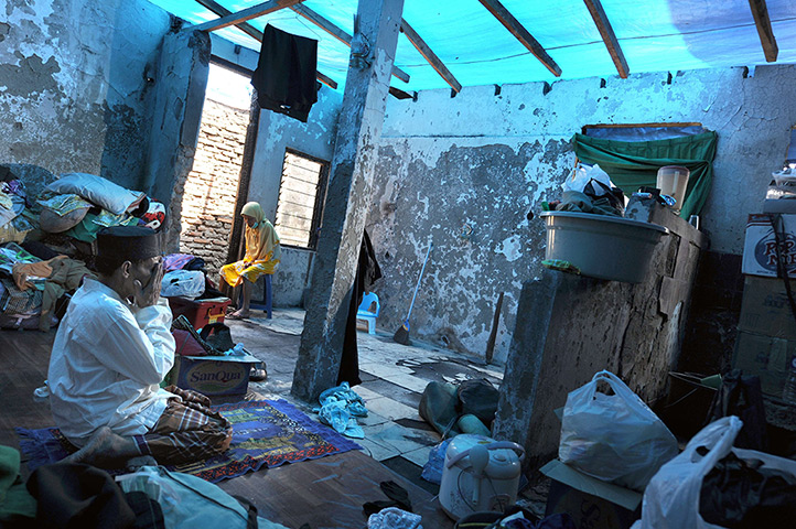 24 hours: Jakarta, Indonesia: A fire victim prays in the ruins of his house 