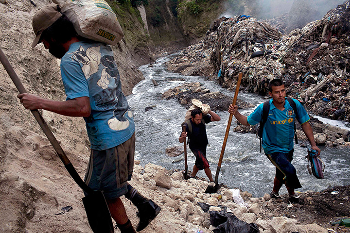 24 hours: Guatemala City, Guatemala: Men carry shovels in a rubbish dump in the city